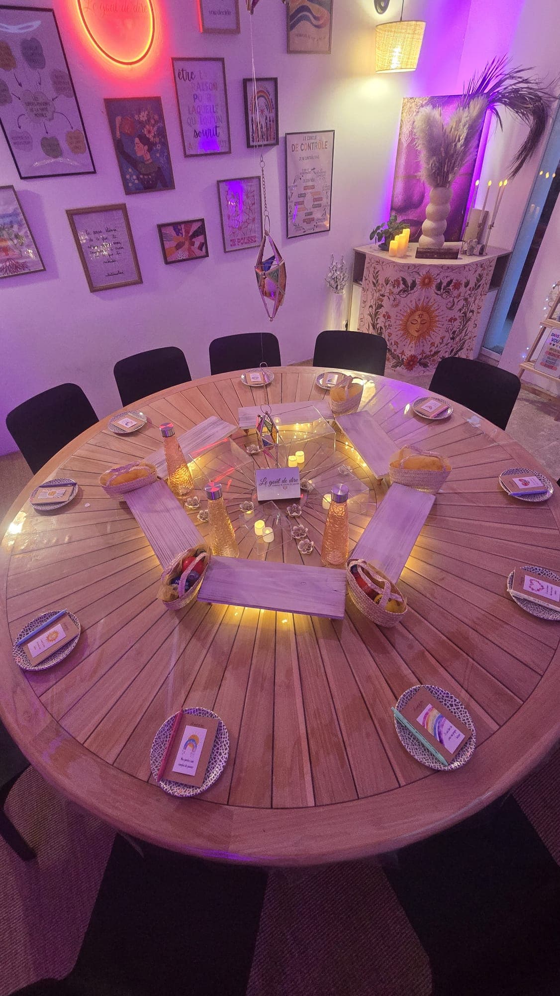 Table ronde en bois dressée avec assiettes, cartes et bougies, vue de près
